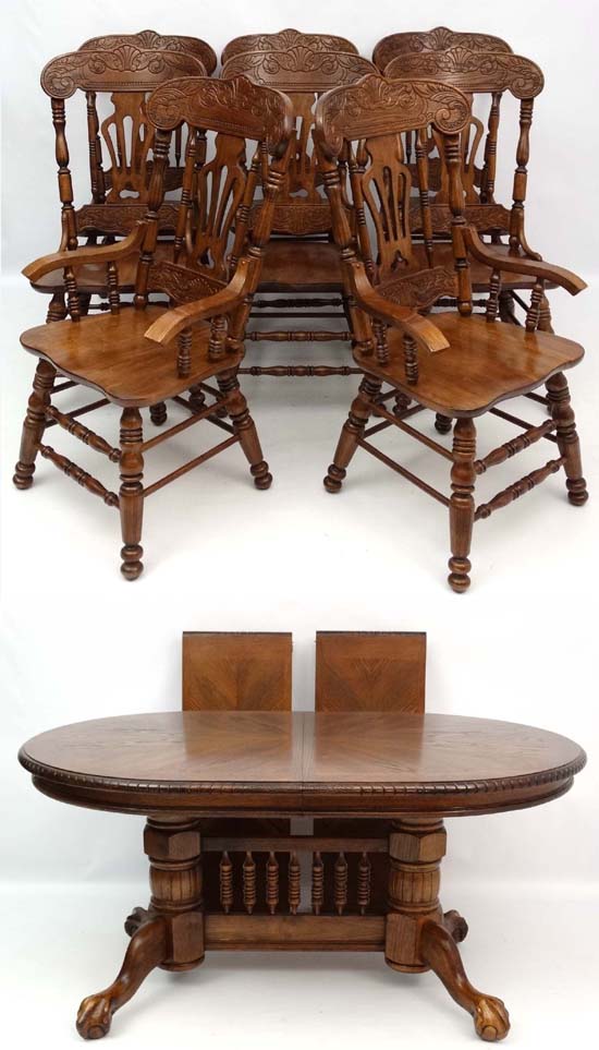 A late 20thC American style twin pedestal extending oak D-ended dining table having 2+6 chairs ( the