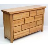 Late 20 th C : a well made blonde oak 12 drawer chest arranged in 4,3,3,2 formation, 17 3/5" deep