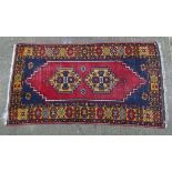 Rug / Carpet :    A hand made woollen rug with blue ground, double medallion to centre and yellow ,