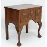 An early 19thC  walnut lowboy with 3 drawers standing on cabriole legs with ball and claw front feet