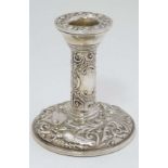A silver candlestick with embossed decoration. Hallmarked Birmingham 1968 maker B & Co. 4" high