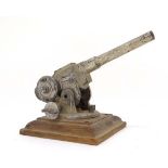 A Diecast Military toy Anti Aircraft Gun, on wooden base, bears remains of indistinct label to base.