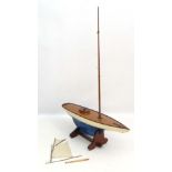 A large 20thC wooden pond yacht on stand, having blue painted wooden hull , mahogany edgeing to deck