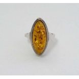 A white metal ring set with amber cabochon to top CONDITION: Please Note -  we do not make reference