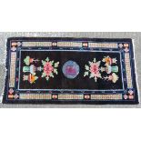Rug / Carpet : a Chinese woollen rug of unusual dark blue ground, with geometric central ground,