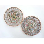 A pair of Cantonese famille rose porcelain plates with reticulated rims, having four decorative