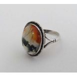 A Sterling silver ring set with moss agate hardstone cabochon to top  CONDITION: Please Note -  we