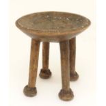 Ethnographica : A native tribal carved wooden four legged stool with remains of inset white shell