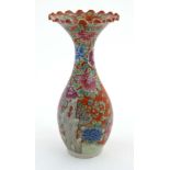 A Chinese hand painted flared rim vase, decorated with flowering boughs of peony's on a rocky