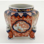 A Japanese tripod jardiniere of hexagonal form in Imari colours , the feet formed as bowing figures,
