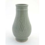 A Chinese Celadon glazed vase decorated in relief with bamboo leaves. 11 1/2'' high.  CONDITION: