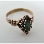 A gilt metal ring set with central emerald bordered by 5 seed pearls  CONDITION: Please Note -  we