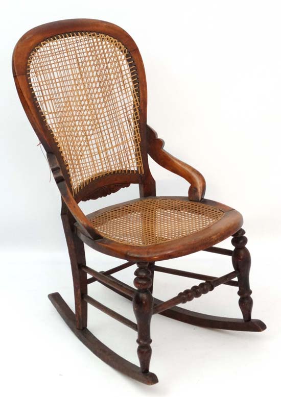 A c.1860 Victorian stained walnut rocking chair with caned seat and back and quantity of restorers