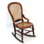 A c.1860 Victorian stained walnut rocking chair with caned seat and back and quantity of restorers