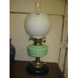 A BLACK BAKELITE TABLE LAMP with pale green glass font, Duplex burner, white opaque glass shade