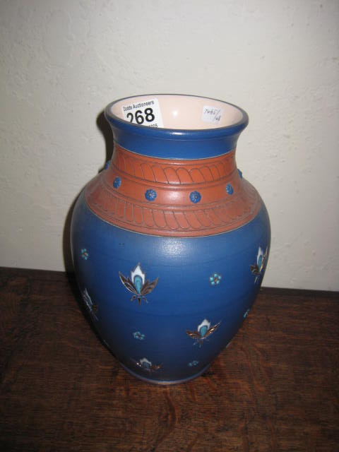 A POTTERY VASE of bulbous form, blue ground with hand painted stylised enamel decoration, 9",