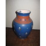 A POTTERY VASE of bulbous form, blue ground with hand painted stylised enamel decoration, 9",