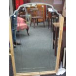 AN ARCHED BEVELLED GLASS WALL MIRROR, 39" x 24", in a retaining frame