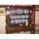 AN OAK CROSS BANDED SHROPSHIRE DRESSER, the enclosed plate rack back having a recessed canopy with