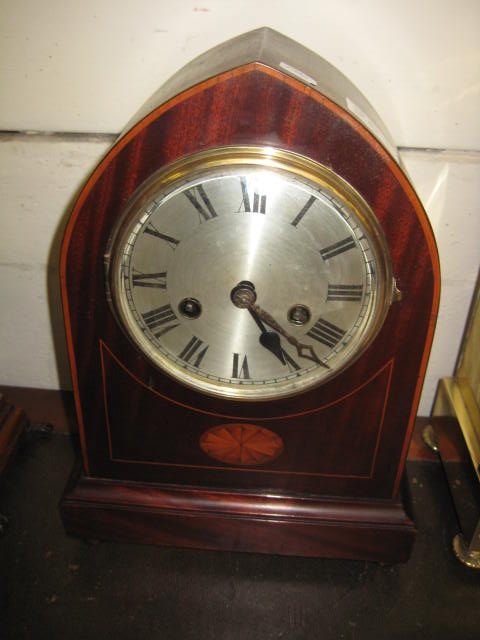 A MANTLE CLOCK having a circular silvered dial with Roman numerals, key wind pendulum moement, in an