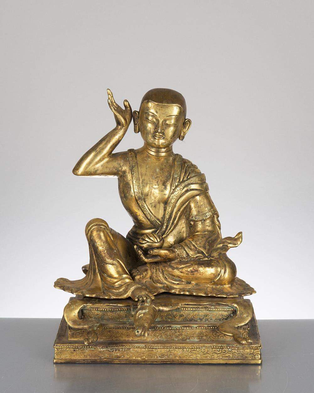 sculpture en bronze doré du Tibet représentant un moine assis sur une peau d'antilope
 sur un