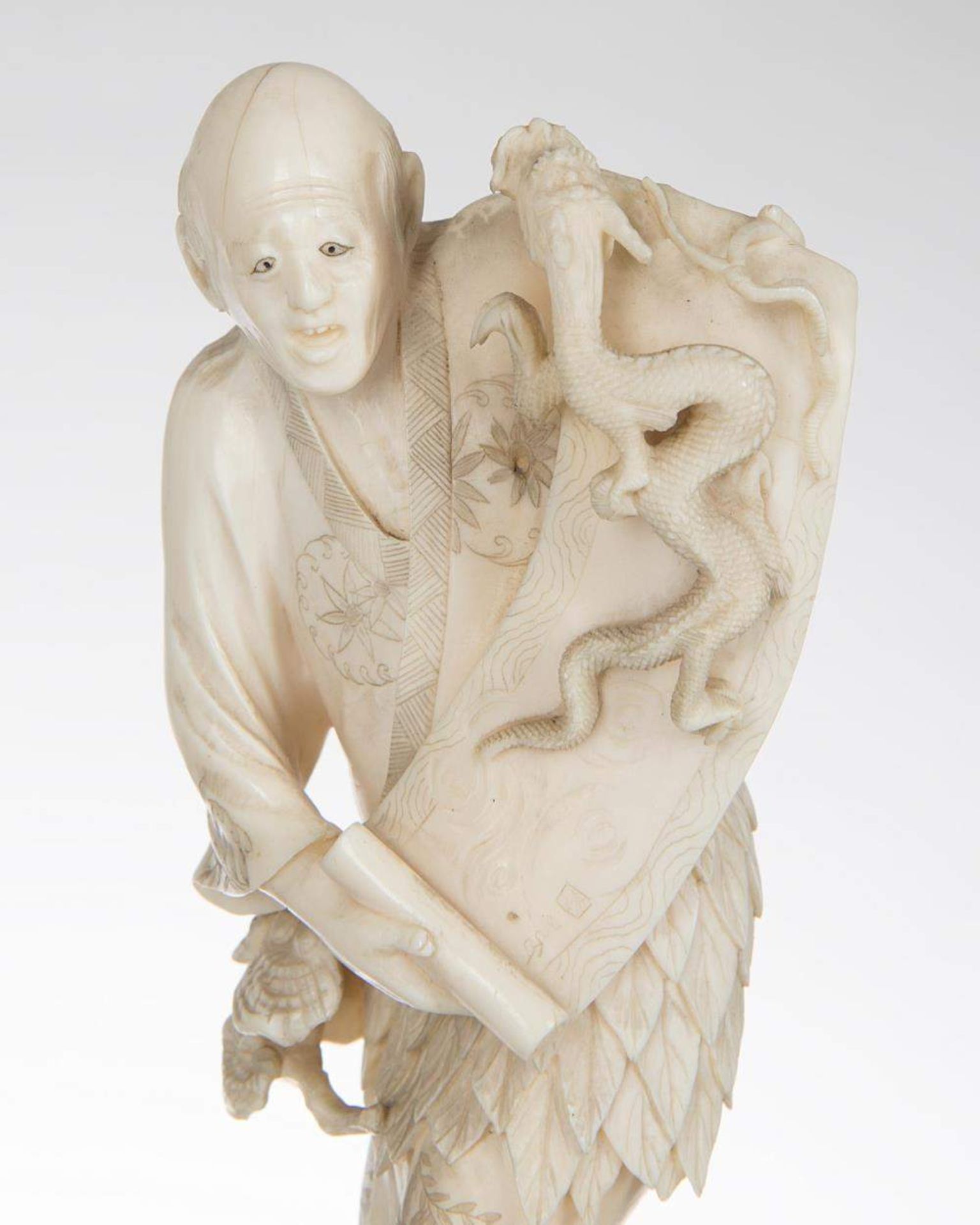 okimono en ivoire représentant un vieil homme déroulant un rouleau duquel sort un dragon des flots - Image 3 of 4