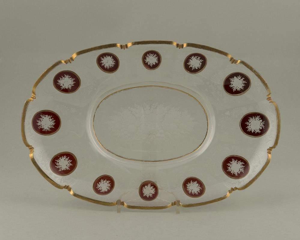 plat ovale en cristal taillé
 à décor floral et médaillons sur champ rouge, bordure à l'or.
Epoque