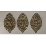 3 ornements ovales en cuivre doré repoussé et ajouré représentant des bouquets de fleurs.

L. 41.