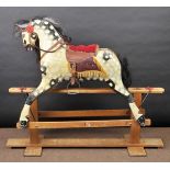 * Rocking horse. A mid-20th century carved and painted dapple grey rocking horse, with harness,