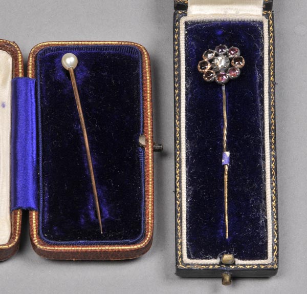 * Tie pins. A Victorian tie pin set with central diamond surrounded by eight garnets, in silver