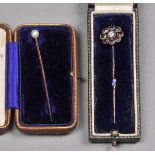 * Tie pins. A Victorian tie pin set with central diamond surrounded by eight garnets, in silver