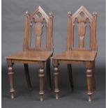 * Chairs. A pair of Victorian oak hall chairs, each Gothic influenced with pierced architectural