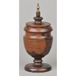 * Treen. A Victorian treen standing cup and cover, with brass finial on a turned pedestal base, 25cm