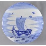 * Charger. An early 20th century Japanese blue and white porcelain charger, decorated with a ship