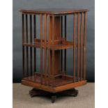 * Bookcase. An Edwardian mahogany revolving bookcase, the square top over divisions with vertical