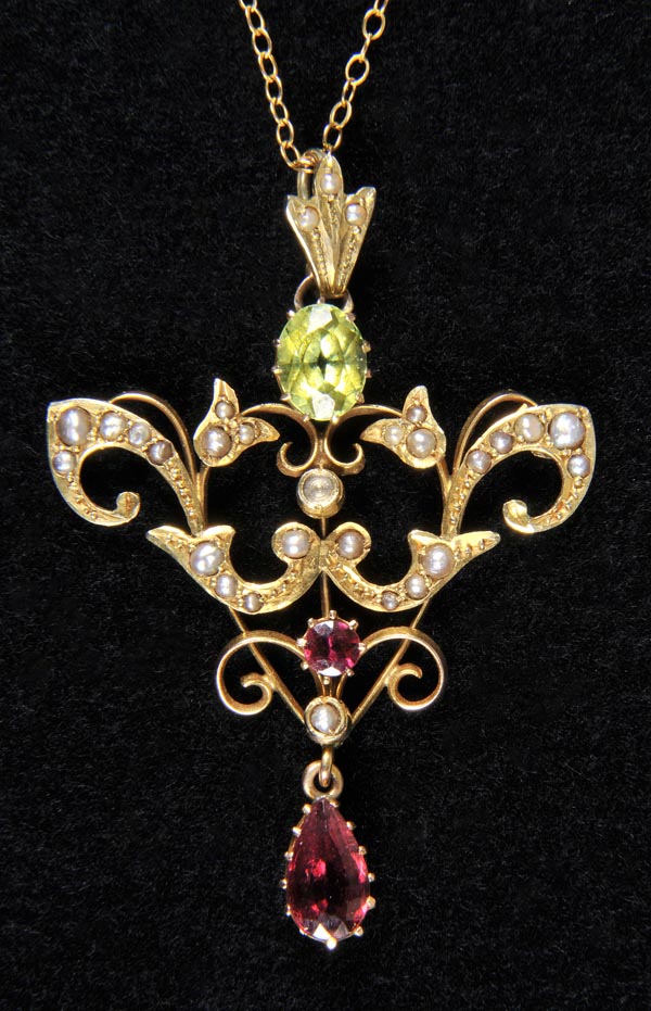 * Pendant. An Edwardian 9ct gold pendant and chain, set with garnets, peridot and pearls within a