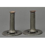 * Liberty & Co. A pair of Tudric pewter candlesticks designed by Archibald Knox, with stylised