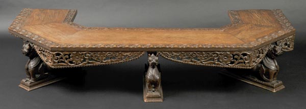 * Bench. An early 20th-century Burmese hardwood seat, of canted form, elaborately carved with