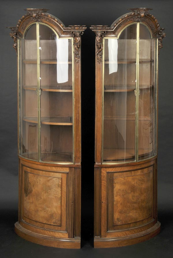 * Cabinets. A substantial pair of late 19th-century walnut display cabinets, curved with foliate