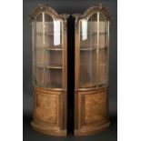 * Cabinets. A substantial pair of late 19th-century walnut display cabinets, curved with foliate
