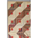 * American Quilt. A large log cabin patchwork quilt, circa 1930s, hand-stitched barn raising