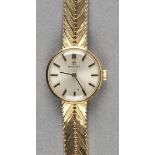 *Omega. A 1960s ladies 9ct gold wristwatch,  the 18mm circular silvered ial with gold raised baton