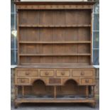 *Dresser. A George III Welsh oak dresser,  with solid three plate rack above a base with radial