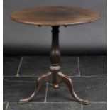 *Table. A George III oak tilt-top table,  the circular top on gun barrel pedestals, with three