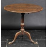 *Table. A George III mahogany tilt-top table,  the circular top on baluster pedestal with three