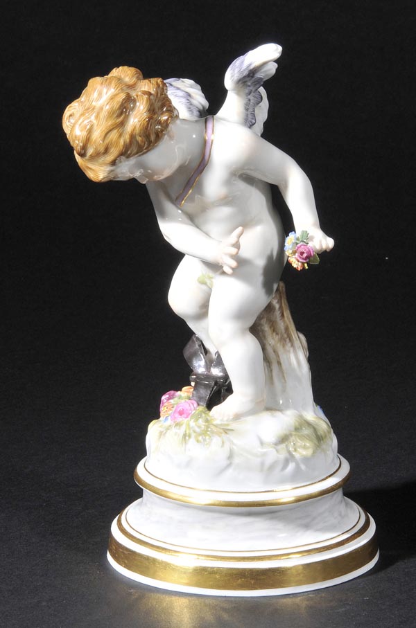 *Meissen. A porcelain figure of Cupid, late 19th century,  holding a small bouquet of flowers,