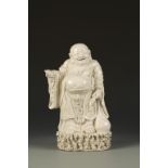 A CHINESE BLANC DE CHINE FIGURE OF BUDAI, the plump Immortal with a jovial expression and holding