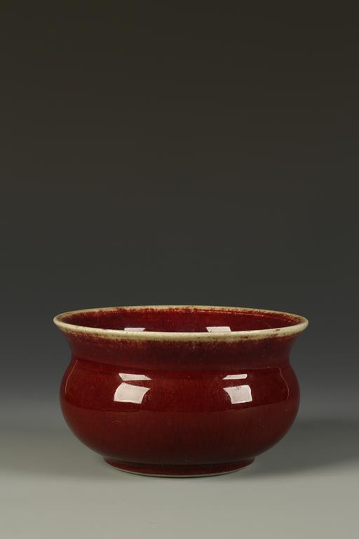 A CHINESE LANGYAO BOMBE CENSER, the flared neck above a rounded body, the deep red glaze with fine