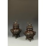 A PAIR OF JAPANESE BRONZE COVERED KORO with lion finials, the bodies modelled in high relief with