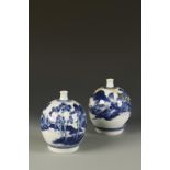 A PAIR OF JAPANESE ARITA BLUE AND WHITE OVOID VASES decorated with buildings in a mountain